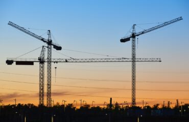 Cranes at sunset. Building under construction. Construction industrial machinery